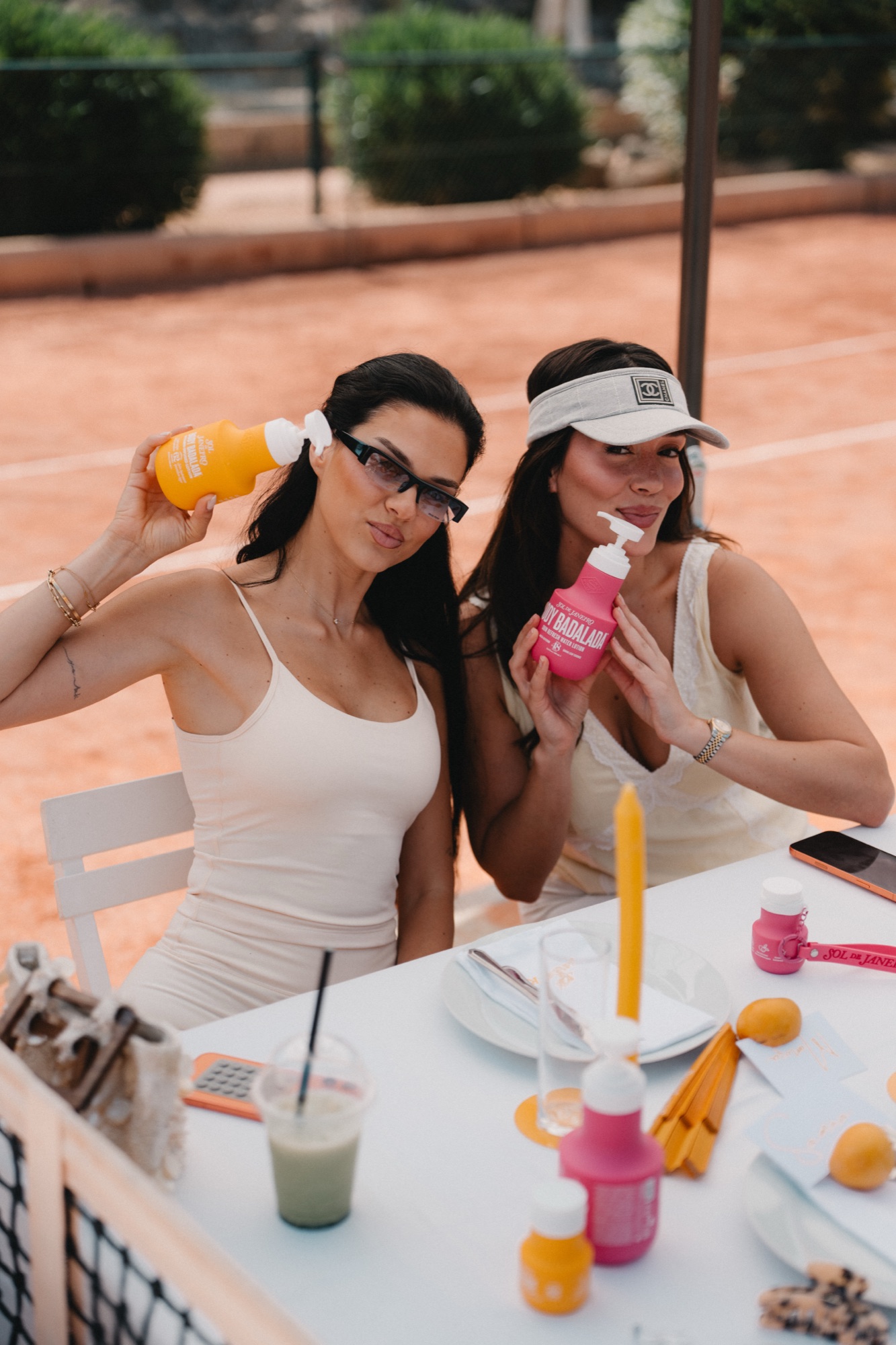 Zwei LYN Creatorinnen zeigen Sol de Janeiro Produkte am Tennisplatz
